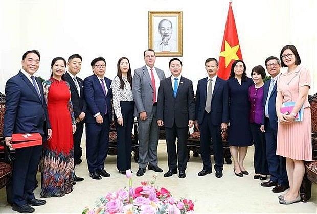 Deputy Prime Minister Tran Hong Ha (sixth from right) and other delegates at the reception. (Photo: VNA)