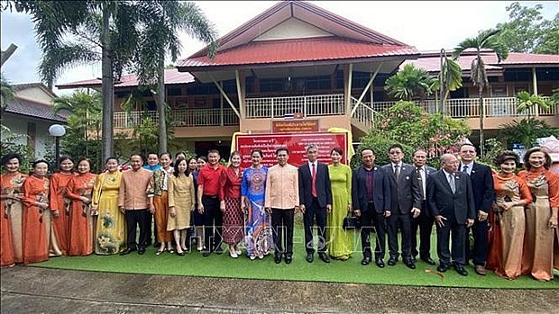 Delegates pose for a photo in front of the Thailand - Vietnam exhibition area in the Thai-Vietnamese Friendship Village in Nakhon Phanom. (Photo: VNA)