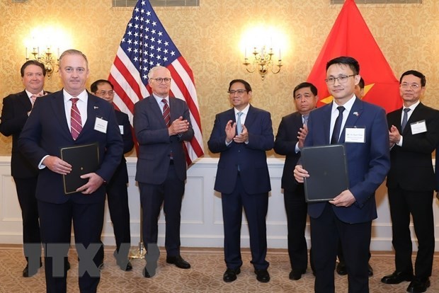Vietnamese Prime Minister Pham Minh Chinh (C, 2nd row) witnesses a ceremony for exchanging signed cooperation agreements between the Vietnamese side and a U.S. firm.