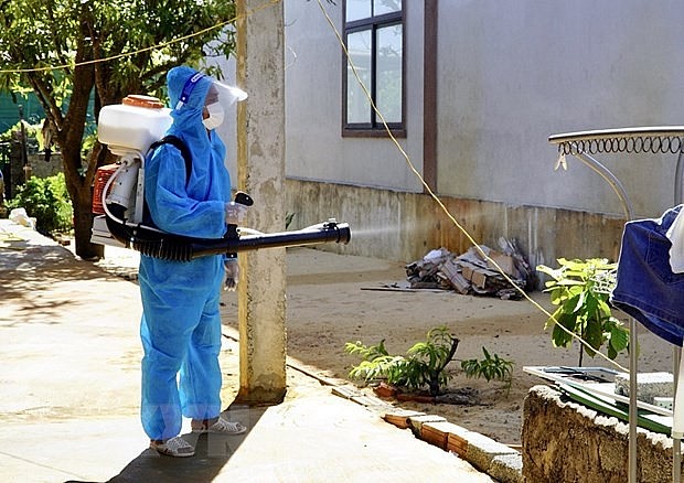 A health worker sprays chemicals to kill mosquitoes. 