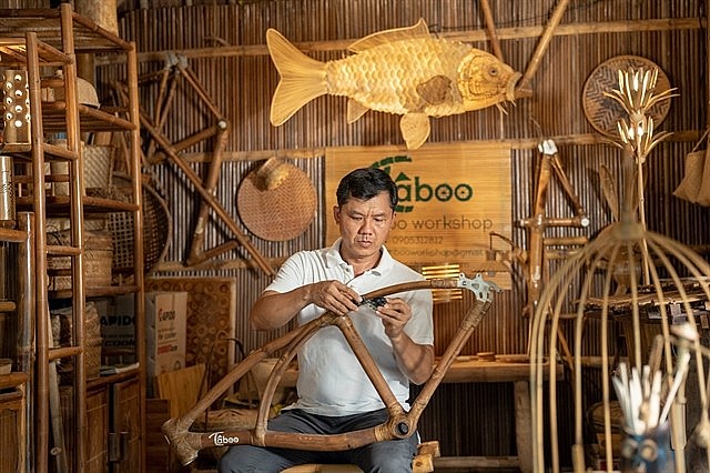 Võ Tấn Tân, a craftsman, is adorning a bicycle frame with bamboo in his personal workshop located in the Cẩm Thanh Commune, Hội An. The historic town is now a proud member of the UNESCO Creative Cities Network (UCCN), specifically in the Crafts and Folk Art category. — Photo courtesy of Sơn Ca