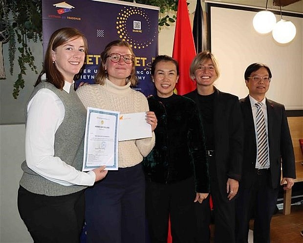 Representatives from Belgian travel firms are presented with air tickets to Vietnam (Photo: VNA)