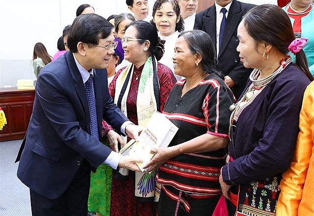 Vice President of the Việt Nam Fatherland Front Central Committee Nguyễn Hữu Dũng presents Party leader Nguyễn Phú Trọng’s book on great national solidarity to ethnic minority representatives at the launching ceremony on Saturday. — VNA/VNS Photo