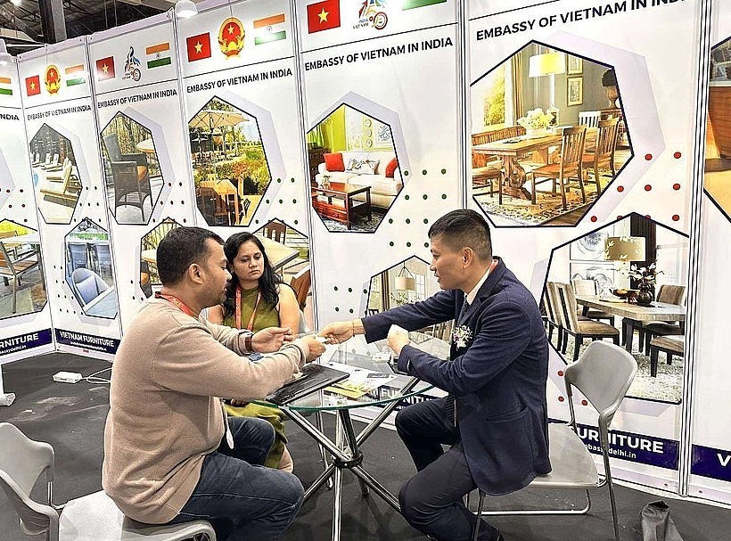 Representatives of the Vietnam Trade Office in India exchange information with visitors to India International Furniture Fair at the Vietnamese product display booth.  Photo: VNA