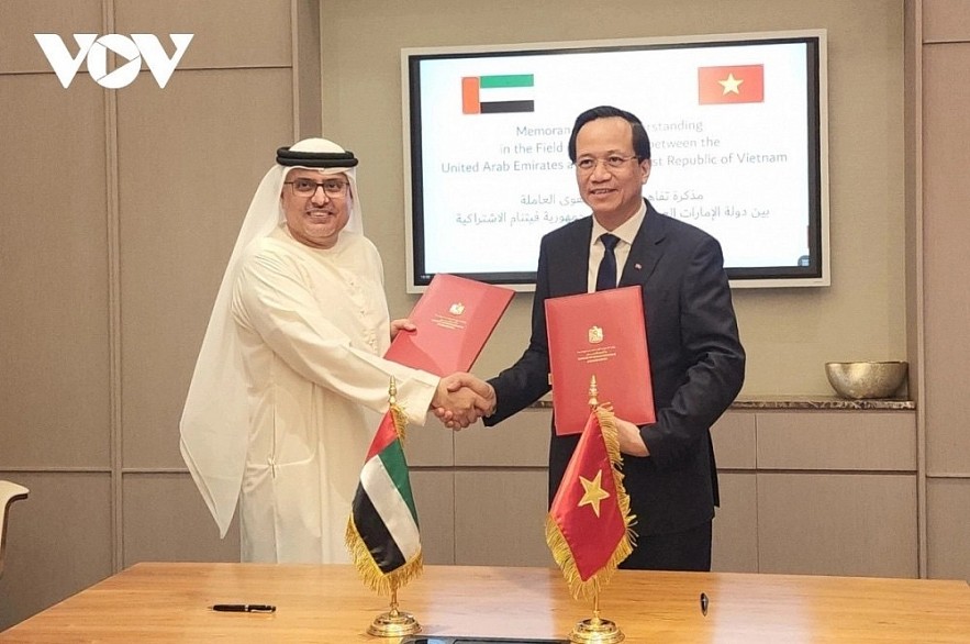Vietnamese Minister of Labour, Invalids and Social Affairs Dao Ngoc Dung and UAE Minister of Human Resources and Emiratisation Abdulrahman Al-Awar exchange the signed document on human resources cooperation between the two countries, following the signing ceremony in Dubai on December 1, 2023