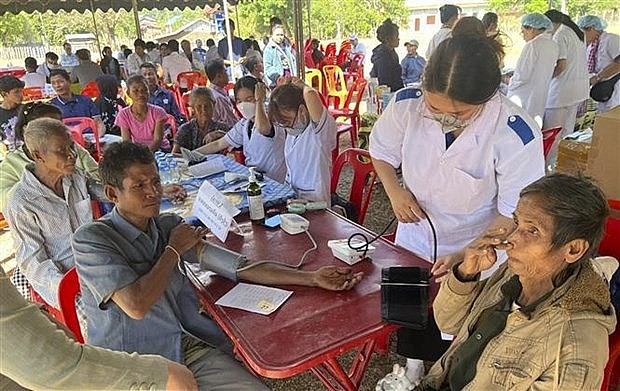 Vietnamese doctors provide free health check-ups for people in Khammouane province, Laos. (Photo: VNA) 