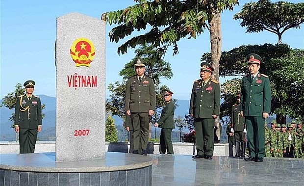 Front, from right: Minister of National Defence of Vietnam General Phan Van Giang, Deputy Prime Minister and Minister of National Defence of Laos General Chansamone Chanyalath, and Deputy Prime Minister and Minister of National Defence of Cambodia General Tea Seiha stand in front of the border marker at the border T-junction of the three countries on December 14 (Photo: VNA)