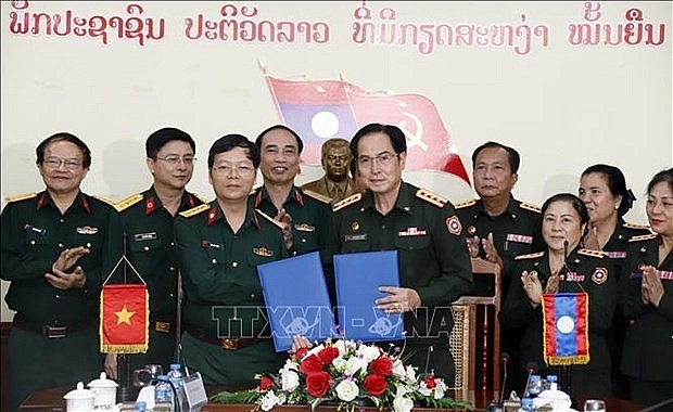 Representatives of Military Hospital 103 of the Vietnam People's Army and Central Hospital 103 of the Lao People's Army exchange the minutes of their discussion at the event (Photo: VNA)