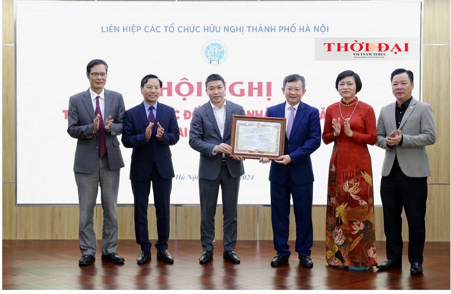 Chairman of the Vietnam Union of Friendship Organizations Phan Anh Son awarded a certificate of merit to HAUFO. (Photo: Dinh Hoa)