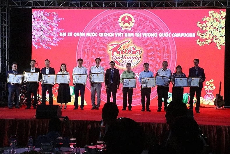 Ambassador Nguyen Huy Tang presents the foreign minister’s certificate of merit to several collectives and individuals for their contributions to the Vietnamese community in Cambodia.