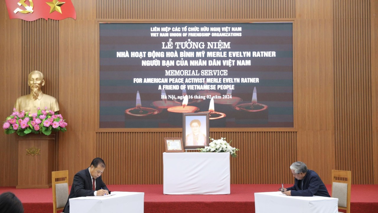 Ambassador Pham Quang Vinh (right) writes in the funeral book saying goodbye to Ms. Merle Ratner. (Photo: Dinh Hoa)