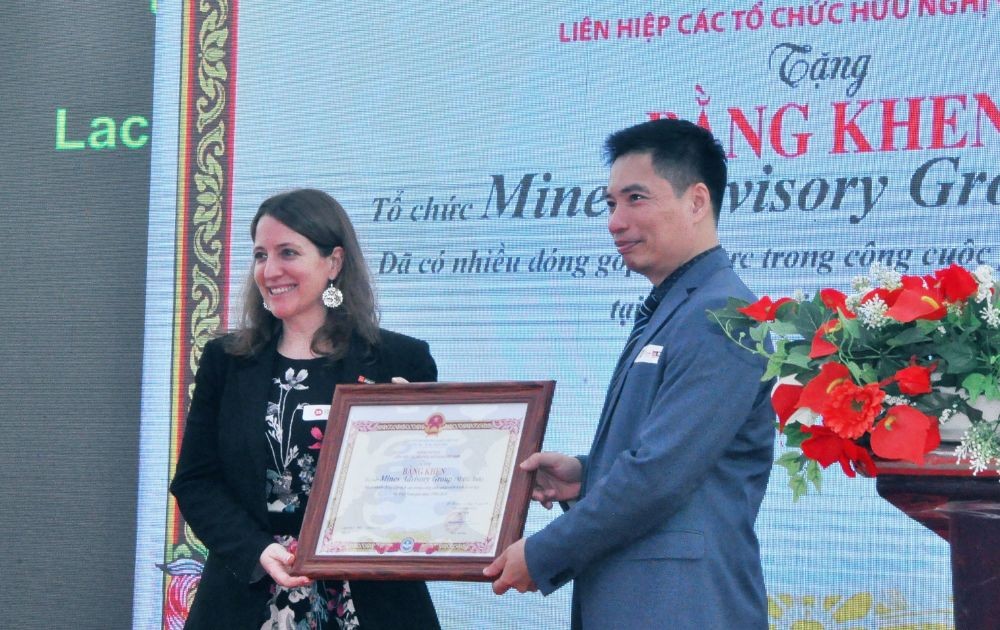 Mr. Tran Phu Cuong (right), Head of the People's Aid Coordination Committee (PACCOM) awarded the certificate of merit from the Presidium of the Vietnam Union of Friendship Organizations to MAG Organization. (Photo: Q.H)