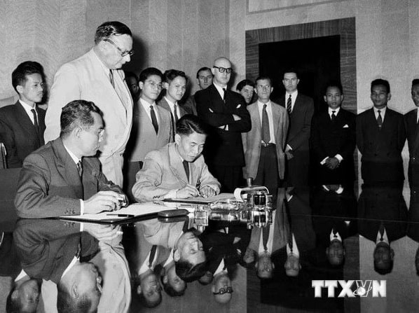 Deputy Minister of National Defence Ta Quang Buu (sitting, right), of the delegation of the Democratic Republic of Vietnam, and French General Henri Delteil, Acting Commander-in-chief of the French Union forces in Indochina, sign the agreement on the cessation of hostilities in Vietnam. (File photo: VNA)