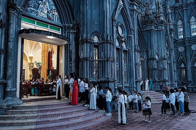People praying outside the church during a service at the parish of Hưng Nghĩa, the northern province of Nam Dinh. Photo: VNA