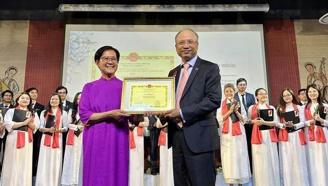 Vietnamese Ambassador Dinh Toan Thang (R) presents the ambassador’s Certificate of merit to the choir in recognition of its contributions. Photo: VNA
