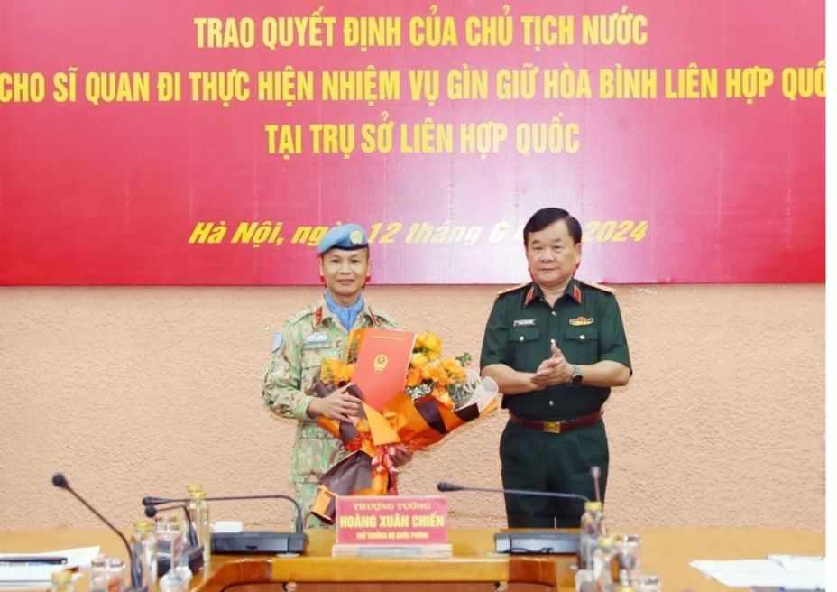 Senior Lieutenant General Hoang Xuan Chien, Deputy Minister of National Defense, Head of the Interdisciplinary Working Group, Head of the Ministry of National Defense Steering Committee presented the President's Decision to Senior Lieutenant Colonel Truong Anh Tuan, military officer of the Department of Peacekeeping peace before leaving for duty at the United Nations. (Photo: Trong Duc/VNA)