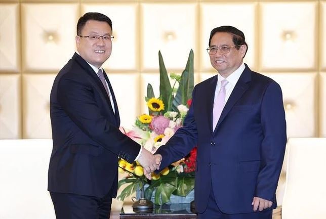 Prime Minister Pham Minh Chinh (right) and Wang Xiaojun, Deputy General Manager of the Power Construction Corporation of China (PowerChina). Photo: VNA