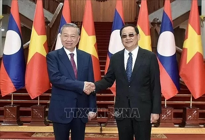 President To Lam meets Lao Prime Minister Sonexay Siphandone in Vientiane.