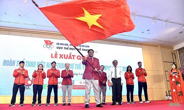 Viet Nam Team's Chef-de-Mission Dang Ha Viet waves the national flag at the Paris Olympics' send-off ceremony on July 17 in Ha Noi.