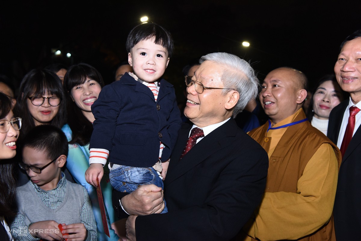 On the night of Lunar New Year’s Eve 2018, General Secretary Nguyen Phu Trong went to the walking street at Hoan Kiem Lake, Hanoi, and talked with people waiting for the New Year's Eve in front of the Ly Thai To monument. He extended New Year's greetings to urban environment workers on duty and gave lucky money to children gathered around Ho Guom with their families. When a child approached, the General Secretary smiled and held the child for a souvenir photo. (Photo: VnExpress)