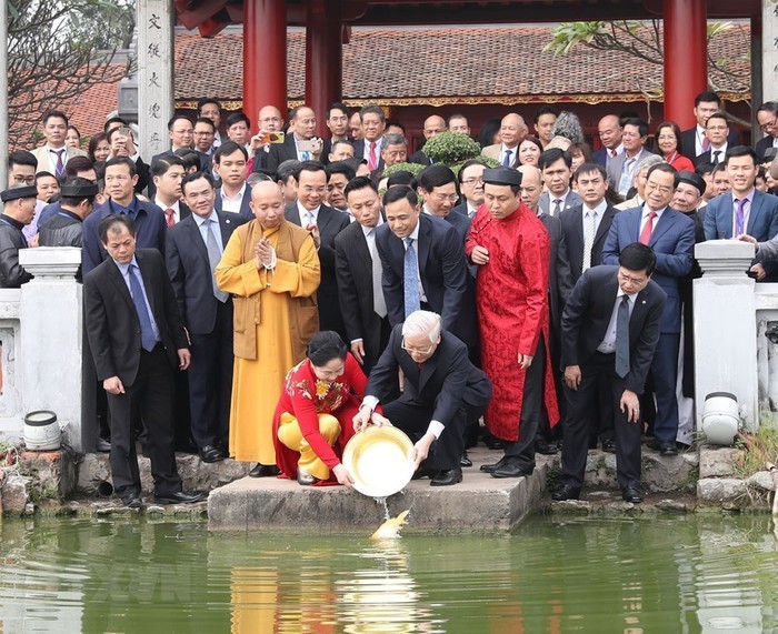 General Secretary Nguyen Phu Trong and his wife, along with overseas Vietnamese, performed the ritual of releasing carps to bid farewell to the Kitchen Gods at Hoan Kiem Lake, Hanoi as part of the Homeland Spring 2019 program. (Photo: VNA)