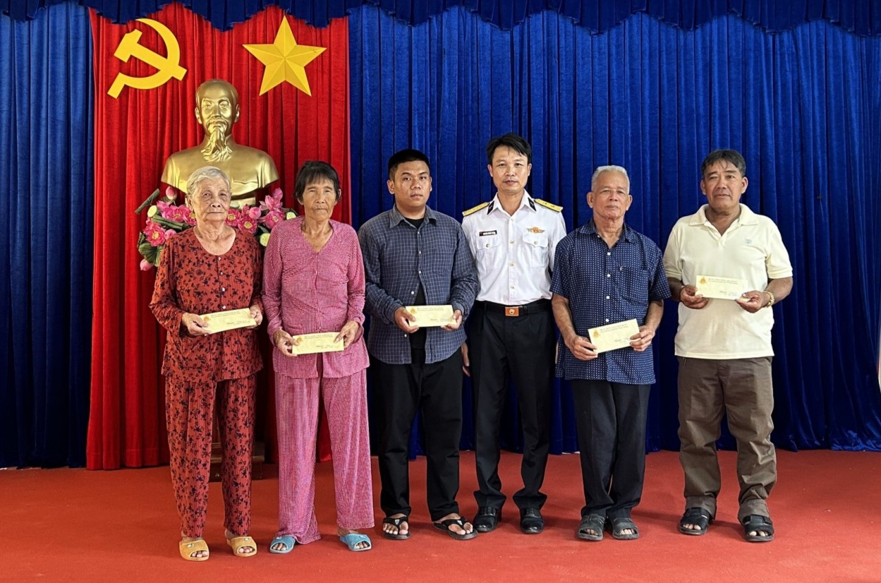 Lieutenant Colonel Nguyen Trung Thong, Deputy Political Commissar of the Technical and Logistics Assurance Center presents gifts to policy families.