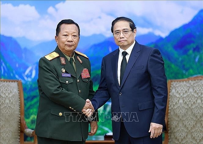 PM Pham Minh Chinh (right) receives General Chansamone Chanyalath, Deputy PM and Minister of National Defence of Laos, in Hanoi on July 25. (Photo: VNA)