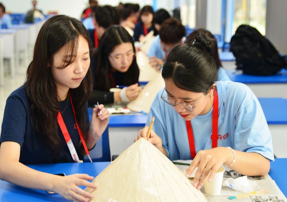 South Korean students enjoyed the experience of decorating conical hats. (Photo: tdmu.edu.vn)