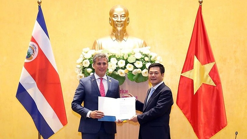 Costa Rica's Foreign Trade Minister presents a diplomatic note recognizing Vietnam as a market economy at a working session with Minister of Industry and Trade Nguyen Hong Dien.