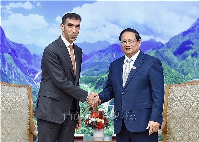 Prime Minister Pham Minh Chinh (R) and UAE Minister of State for Foreign Trade Thani bin Ahmed Al Zeyoudi, Hanoi, August 26 (VNA)