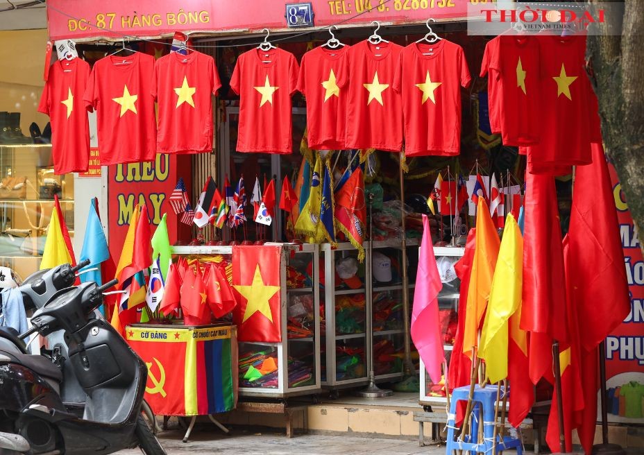 A vendor on Hang Bong Street in Hoan Kiem District sells national flags and T-shirts. (Photo: Dinh Hoa)