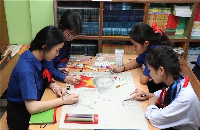 Students at the Nguyen Du Lao-Vietnamese bilingual school draw a portrait of President Ho Chi Minh. (Photo: Xuan Tu/VNA)