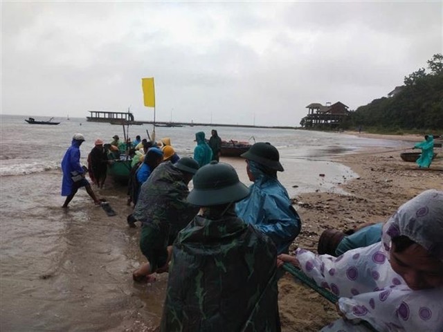 Border soldiers at Cua Dai Border Guard Command in Quang Nam Province help residents move their boats to safe places. (Photo: VNA)