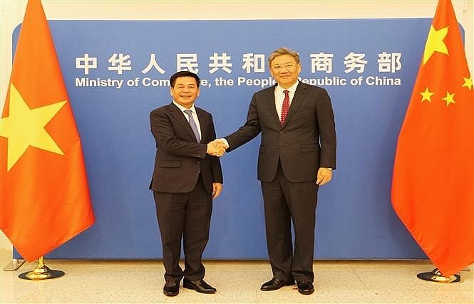 Minister of Industry and Trade Nguyen Hong Dien (L) and Chinese Minister of Commerce Wang Wentao shake hands before co-chairing the 13th session of the Vietnam-China Economic and Trade Cooperation Committee (Photo: VNA)