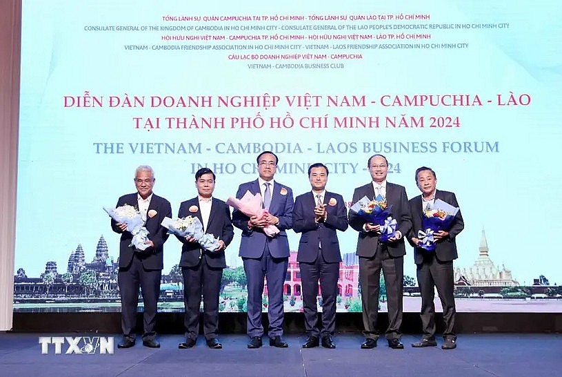 Vice Chairman of the Ho Chi Minh City People's Committee Bui Xuan Cuong (3rd from right) gives flowers to representatives of the forum organizing board. (Photo: VNA)