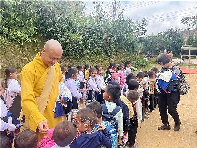 Most Venerable Thich Minh Quang and Vietnamese expatriates in Laos present relief packages to Lao residents (Photo: VNA)