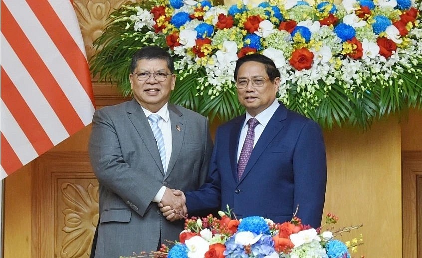 Prime Minister Pham Minh Chinh (R) welcomes Speaker of the Malaysian House of Representatives Tan Sri Dato' Johari Bin Abdul.