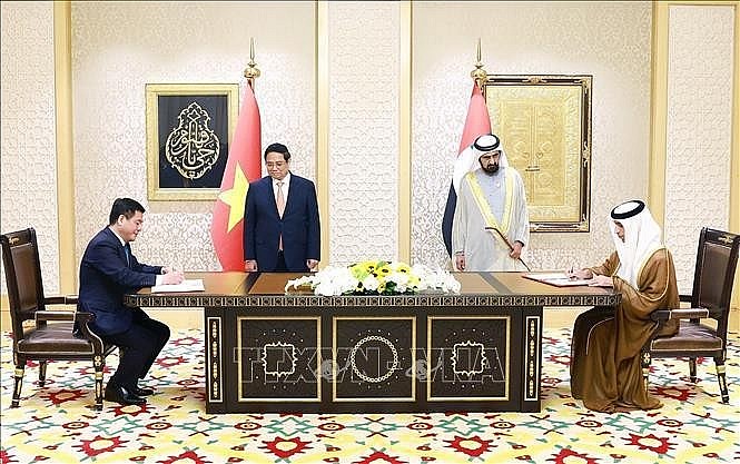 Prime Minister Pham Minh Chinh (left) and Vice President and Prime Minister of the United Arab Emirates (UAE) Sheikh Mohammed bin Rashid Al Maktoum witness the signing of the Comprehensive Economic Partnership Agreement. (Photo: VNA)