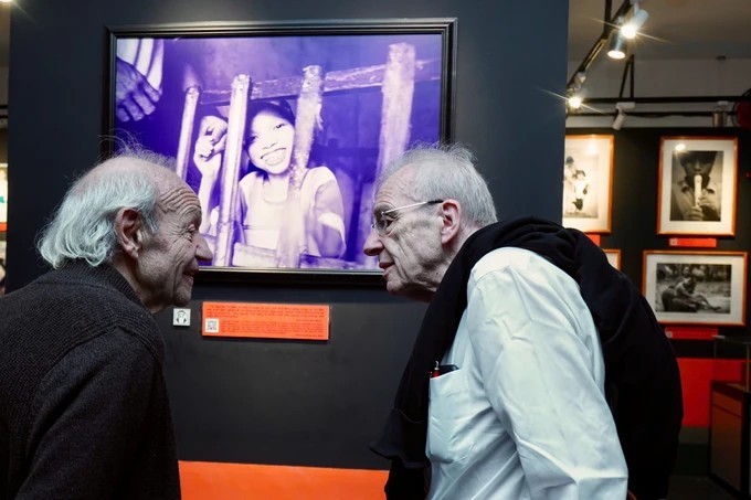 Olivier Parriaux and Mr. Bernard Bachelard discussed while viewing a photo at the War Remnants Museum. (Photo: Saigon Giai Phong Newspaper)