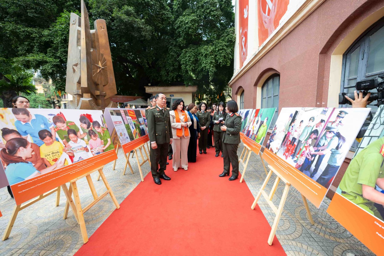 Delegates visit and listen to explanations about the photos displayed at the exhibition.