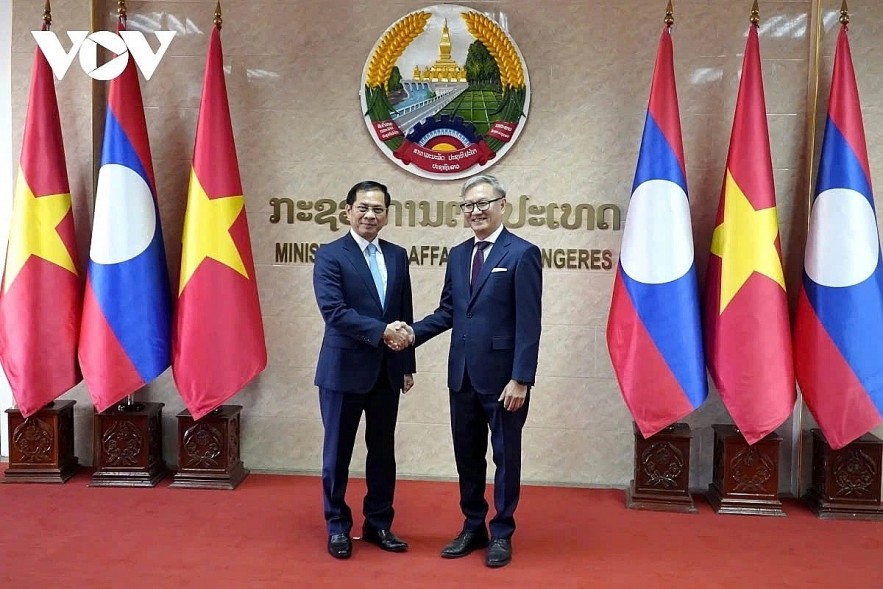 Lao Foreign Minister Thongsavanh Phomvihane (R) shaking hands with visiting Vietnamese Deputy Prime Minister and Foreign Minister Bui Thanh Son, ahead of the 11th Vietnam-Laos Foreign Ministerial Political Consultation in Vientiane on December 16.