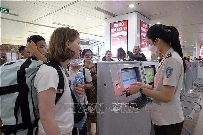 Security personnel checks passengers' information at Noi Bai International Airport. (Photo: VNA)