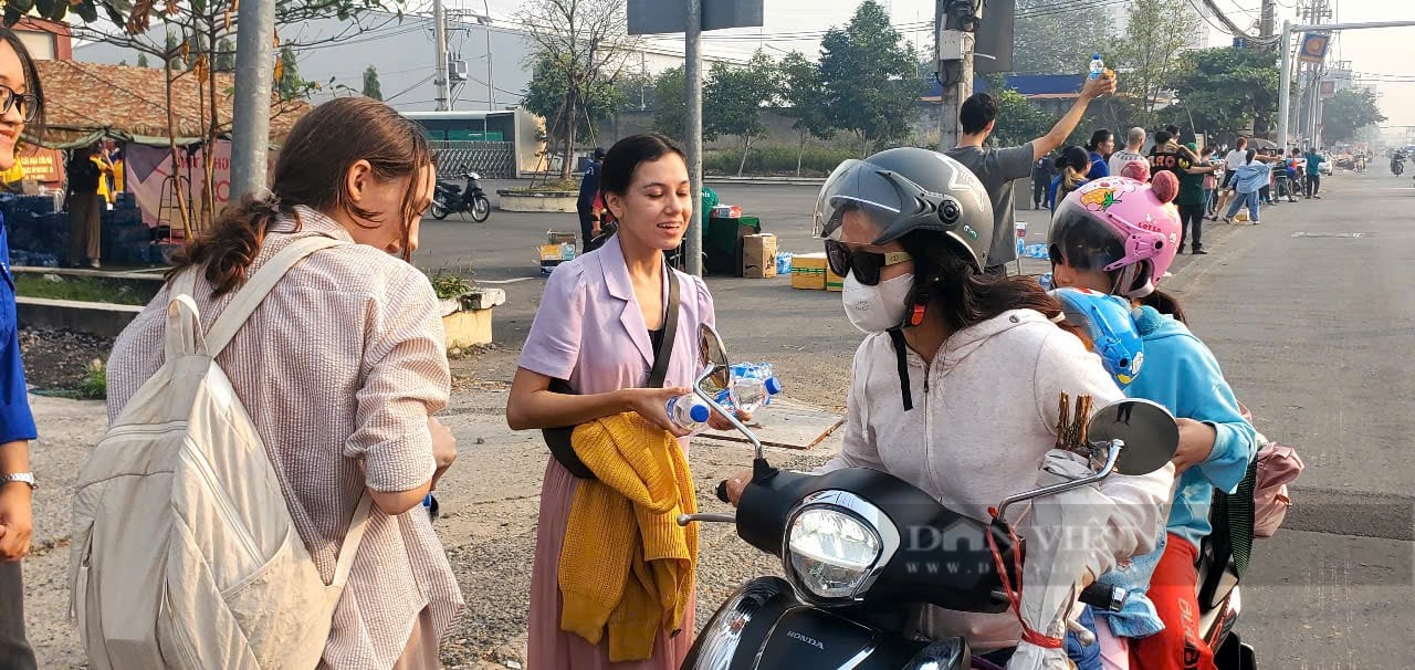 People happily and excitedly return to their hometowns after receiving mineral water as gifts from foreigners. (Photo: Chinh Hoang/Dan Viet Newspaper)