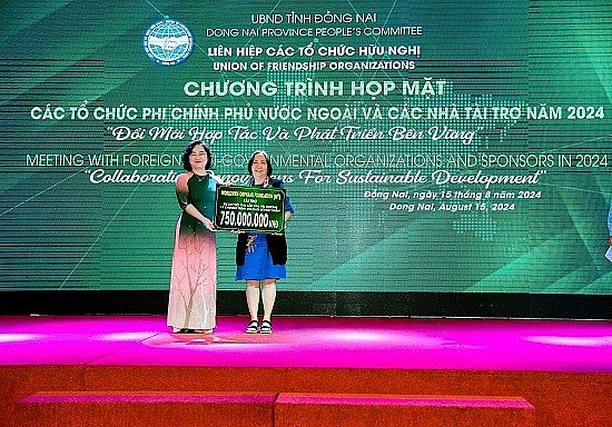 Vice Chairwoman of the Union of Friendship Organizations of Dong Nai Province, Vy Vu Hong Thao, receives a symbolic donation board from the WWO/USA organization. (Photo: dufo.dongnai.gov.vn)