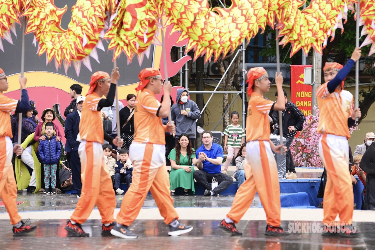 Foreign tourists attentively watch the dragon dance performance at the Dong Da Mound Festival (Hanoi). (Photo: Suc khoe & Doi song)