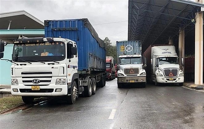 Freight vehicles await customs clearance at Lao Bao International Border Gate in Quang Tri province. (Photo: VNA)