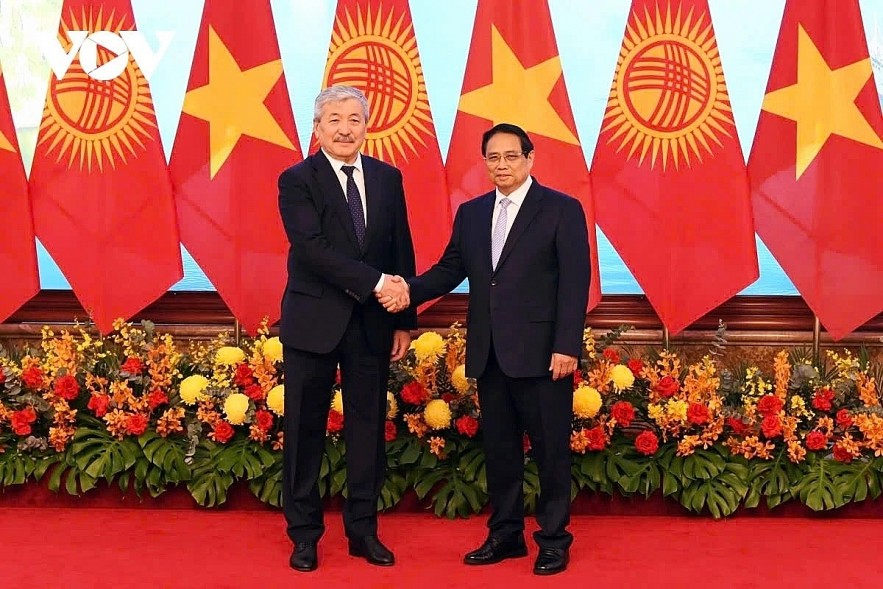 Vietnamese Prime Minister Pham Minh Chinh (R) and his visiting Kyrgyz counterpart Adylbek Kasymaliev shaking hands ahead of their talks in Hanoi on March 6.