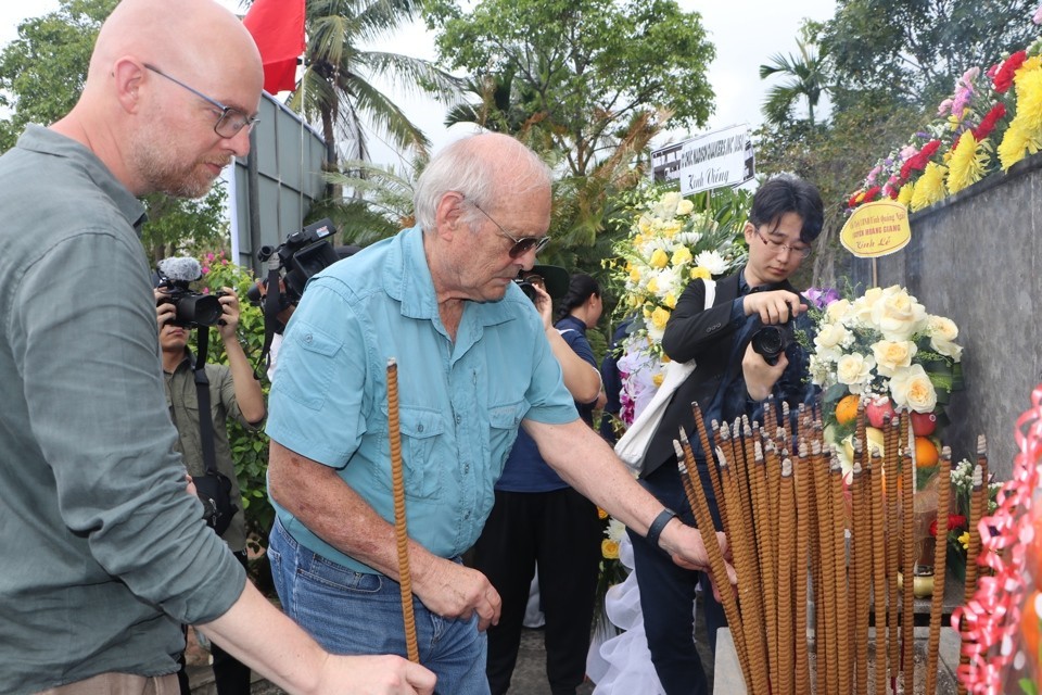 Ronald L. Haeberle (in blue), the author of the photos of the Son My Massacre, offers incense at the memorial ceremony. (Photo: Kinh Te & Do Thi)