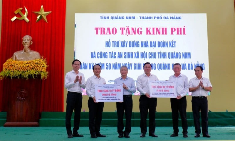 Permanent Deputy Secretary of the Da Nang Party Committee Nguyen Dinh Vinh and Chairman of the Vietnam Fatherland Front Committee of Da Nang Le Van Trung present VND 10 billion and 100 houses to Quang Nam. (Photo: Nguyet Anh/danang.gov.vn).