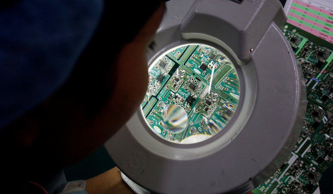 A woman inspects a circuit board at Manutronics Factory in Bac Ninh province, Vietnam